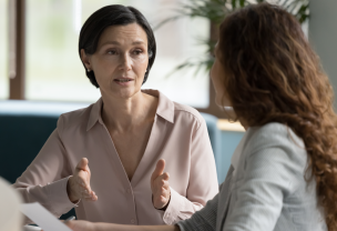 Two women talking in an open office